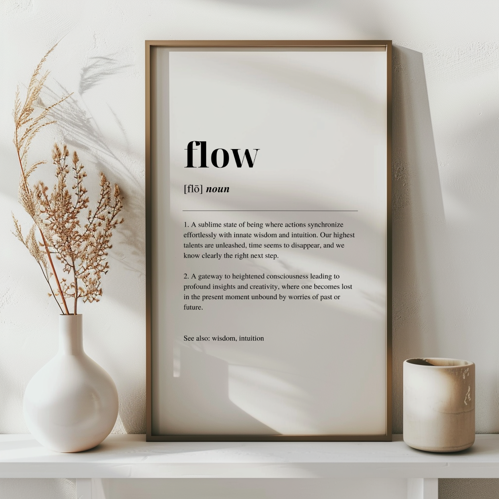 A fine art print with the word 'Flow' defined in a minimalist style, displayed in a wooden frame, with a dried plant to the left.