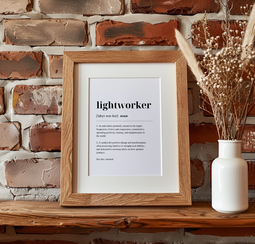 Wood framed poster on a mantlepiece with inspirational definition art text for the word and meaning of a Lightworker. A dried plant in a vase is next to the poster