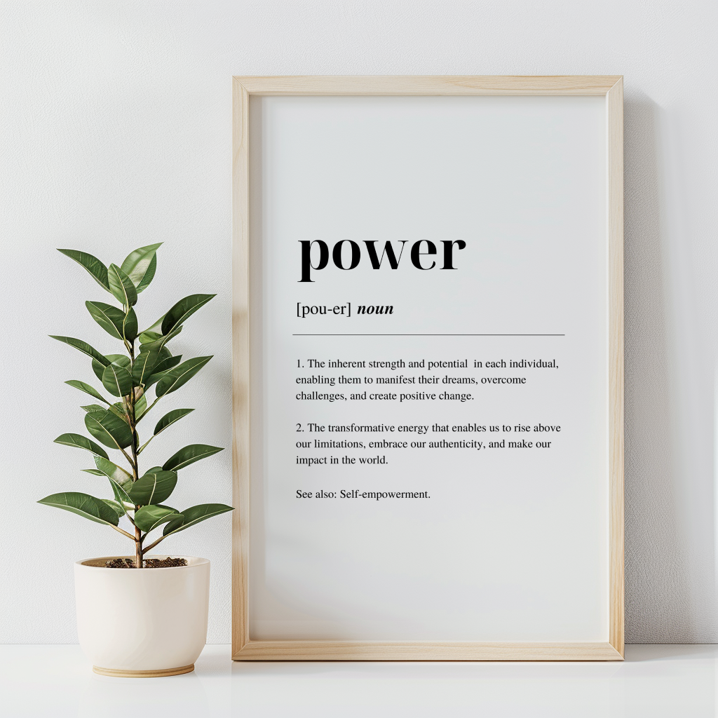 A digital art print with the word 'POWER' written in black capital letters, defined as 'the ability to transform weakness into strength and to face challenges with determination'. The print is framed in a wooden enclosure, displayed on a white wall, with a vase with a leafy plant  to the left.